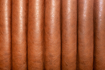 Leather upholstery of a sofa and upholstered furniture as a background or texture for advertising a furniture store. Brown, beige, gold leather for furniture and design.
