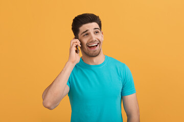Young caucasian man on orange background in studio