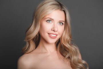 Fototapeta premium Close-up portrait of a beautiful young blonde woman with luxurious hair.