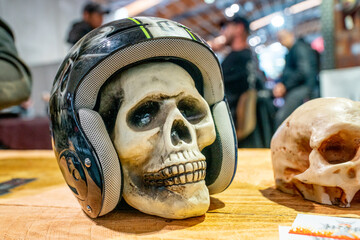 The skull of a man in a protective helmet stands on the table. Security concept. Protection against...