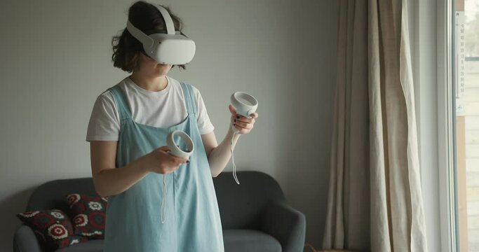Woman in VR goggles playing game at home