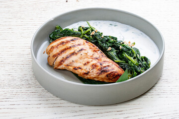 Fried chicken fillet with Greek dzadziki sauce and stewed spinach.