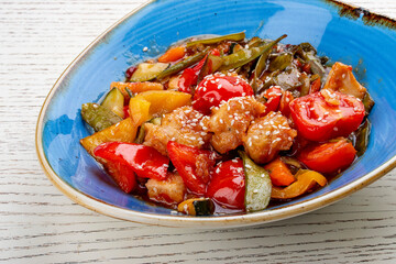 Asian-style chicken with sweet and sour sauce and vegetables.