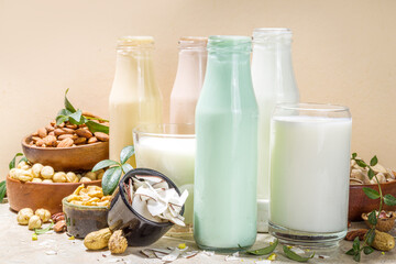 keto, paleo and vegan diet concept. Set of nut milks, bottles with various non-dairy nut milk - pistachio, walnut, hazelnut, peanut, almond, cashew, pecan, brazil nut, seeds, coconut