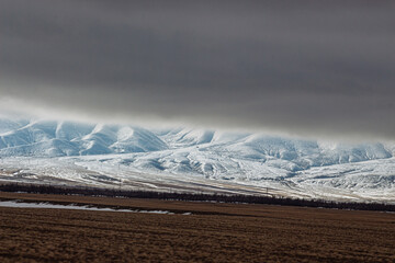 amazing mountains under grey clouds and reflection in mountain lake