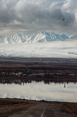 amazing mountains under grey clouds and reflection in mountain lake