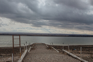 amazing mountains under grey clouds and reflection in mountain lake