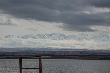 amazing mountains under grey clouds and reflection in mountain lake