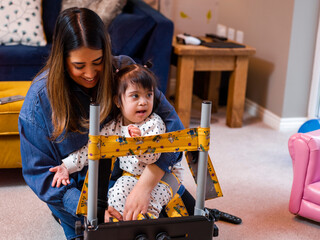 Mother putting daughter in standing frame