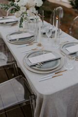 Elegant destination wedding table setting featuring a neutral color palette fine tableware floral arrangements and personalized menus. A perfect image for luxury events, receptions, and celebrations
