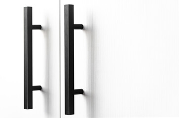 white wood cupboard door by black handle. Modern kitchen furniture concept. Cozy apartment details