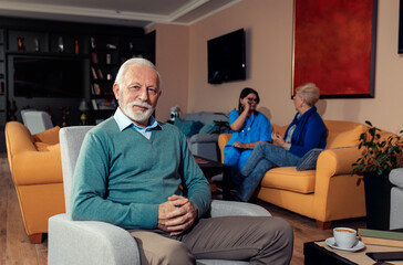 Fototapeta premium Portrait of senior man siting in armchair at nursing home.
