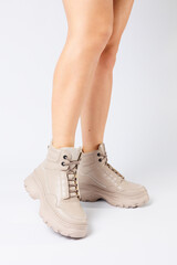 Female legs in beige leather shoes from the new collection on a white background female legs in fashionable shoes made of eco-leather spring 2022.