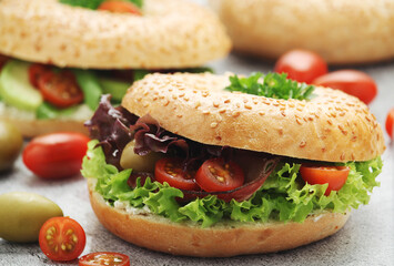 Sesame bagels with tomatoes, ham and olives