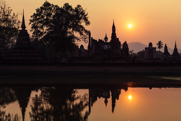 Fototapeta na wymiar Sukhothai historical park, Wat Mahathat ruins at sunset. One of most beautiful and worth seen place in Thailand. Popular travel destination while visiting southeast Asia.