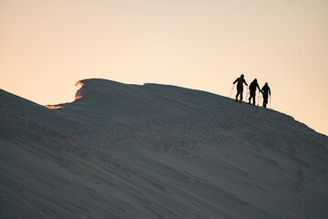 Fototapeta na wymiar snow-covered mountain slope with walking skiers on it. Ski touring and freeride concept