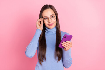 Photo of charming glad sincere lady hold telephone wear eyewear blue turtleneck isolated pink color background
