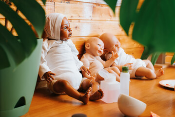 Reborns of different races, handmade afro american and caucasian newborn dolls on table in home...