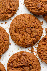 chocolate biscuits on a white surface, closeup view of round shape homemade snack taken from above