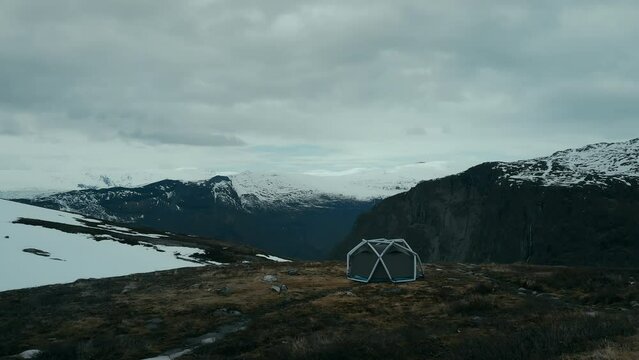 Aerial drone footage of basecamp with tents set up on high altitude in mountains