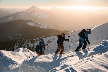 group of skiers climbing up at snow-covered mountain trail against the backdrop of a beautiful...