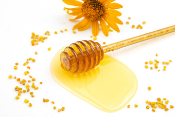 spoon with fresh honey and pollen spilled on a white background. organic vitamin food