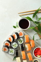 Concept of tasty food with sushi rolls on white textured background