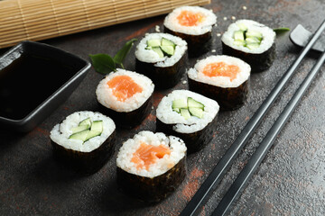 Concept of tasty food with maki on dark textured background
