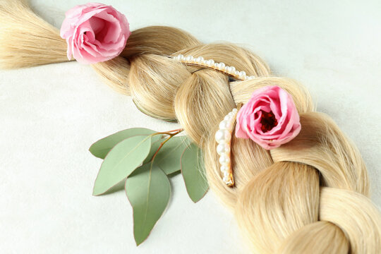 Female hair with flowers and hair clips on light background