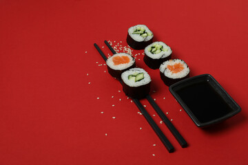 Concept of tasty food with maki on red background