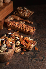 Mix of nuts and raisins on a brown rustic background.