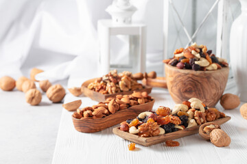 Mix of nuts and raisins on a white wooden table.