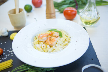Pasta with seafood on a black stone table. Top view