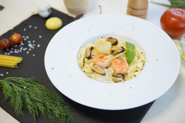 Pasta with seafood on a black stone table. Top view