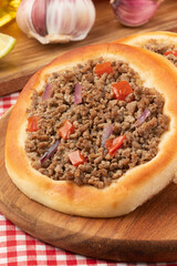 Arabic meat sfiha on cutting board.