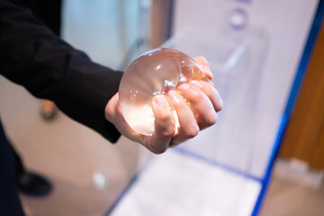 A young man is experimenting with breast augmentation silicone for cosmetic surgery.