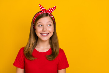 Photo of cute teenager girl look empty space wear red t-shirt headband isolated on yellow color background