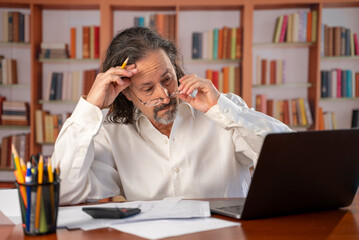 Frustrated mature man feels angry unable to do tax prep successfully get debt deficit try to find mistake in calculations. Annoyed male count business costs think on bankruptcy risks too high taxes