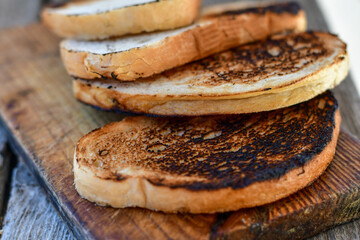 White bread toasted on an outdoor Grill on wooden table