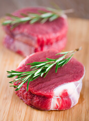 Raw Beef Tenderloin with Rosemary on a Cutting Board