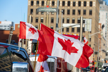 View of two Canadian flags, smaller one upside down supporting Canadian trucker street protest...