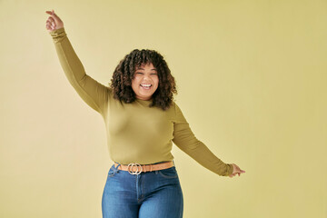 Studio shot of smiling young woman dancing