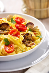 Seafood Tagliatelle Noodles with Fresh Tomatoes on a Plate.