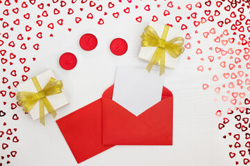 Composition of handmade paper gift boxes, candles, envelope, leaflet. Sequins hearts on a white wooden table. Content for Birthday, Valentines Day, Womens day. Flat lay, top view, close up, copy space