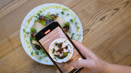 girl blogger shoots a dish with food on her smartphone