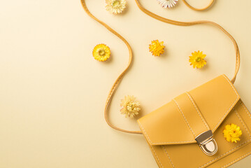 Top view photo of woman's day composition yellow leather handbag and field flowers on isolated beige background with copyspace - obrazy, fototapety, plakaty