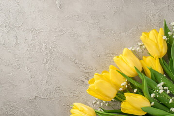 Top view photo of woman's day composition bouquet of yellow tulips and white gypsophila on isolated textured grey concrete background with copyspace
