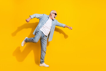 Full length body size view of attractive cheerful motivated grey-haired man having fun isolated over shine yellow color background