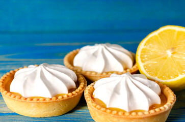Lemon tartlets, Homemade shortbread mini tart cakes with lemon curd and whipped cream, blue background