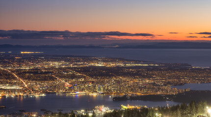 View of Top of Grouse Mountain Ski Resort with the City in the background. North Vancouver, British Columbia, Canada. Sunset Sky